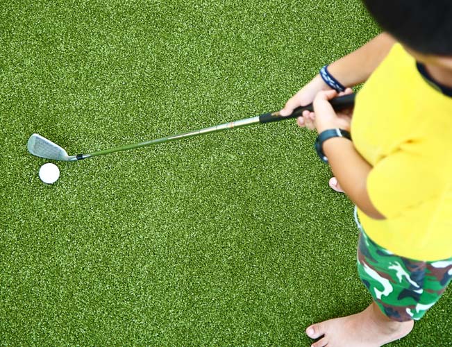 young golfer driving golf ball